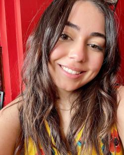 Close-up portrait of a smiling woman with long brown hair.