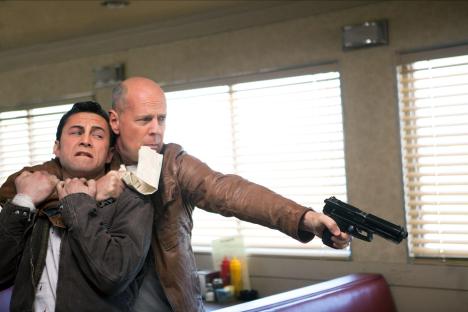 Still from Looper showing Bruce Willis holding Joseph Gordon-Levitt at gunpoint.
