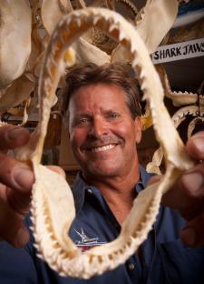 A man holding a large shark jaw.