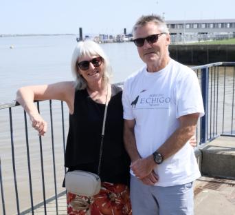 Couple posing by a waterfront railing.