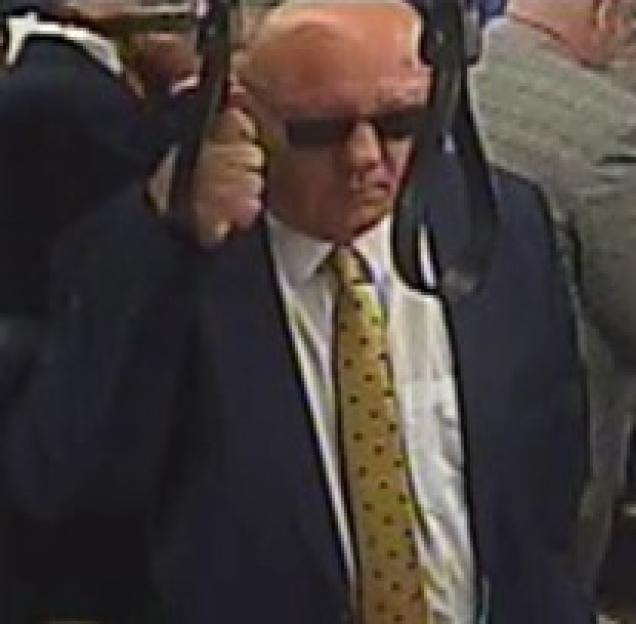 Man in suit and sunglasses on public transportation.