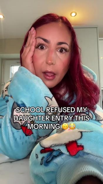 Woman in a blue robe says school refused her daughter entry.