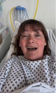 Lorraine Kelly in a hospital bed, speaking to the camera.