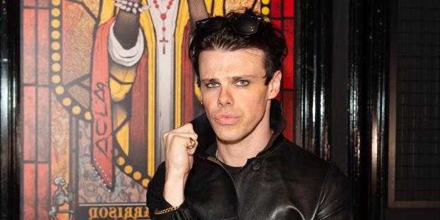 Yungblud at a Q&A event, standing in front of stained-glass artwork depicting him.