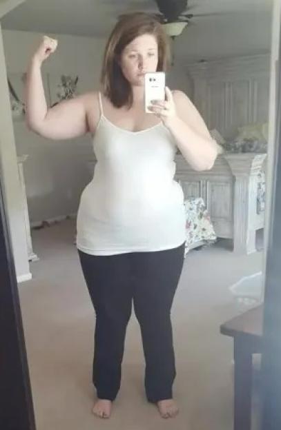 A woman holding up a photo of herself before weight loss.