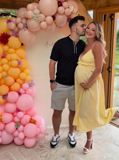 Pregnant woman and her partner at a baby shower.