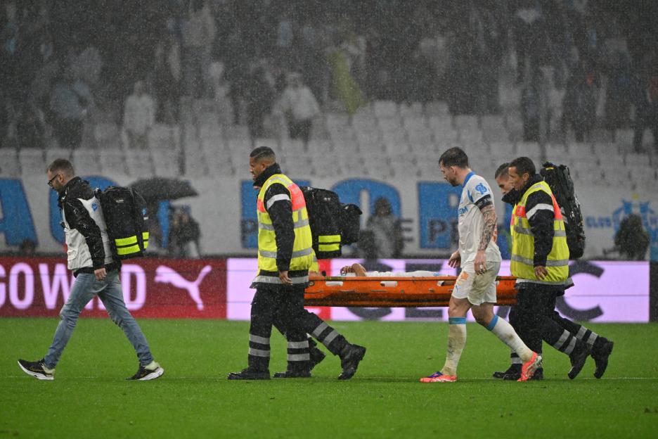 Bilal Nadir being evacuated on a stretcher with the assistance of medics and Pierre-Emile Hojbjerg during a football match.