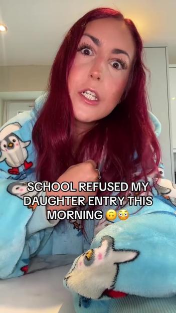Woman in penguin pajamas reports her daughter was refused entry to school.