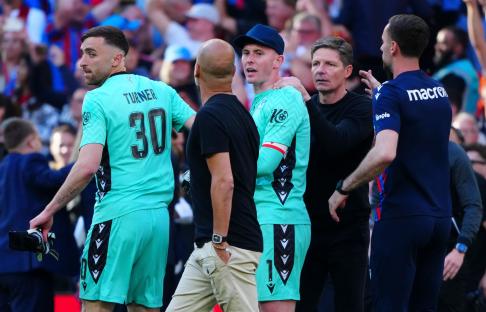 Pep Guardiola and Dean Henderson arguing at a soccer game.