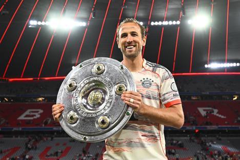 Harry Kane holding the Bundesliga trophy.