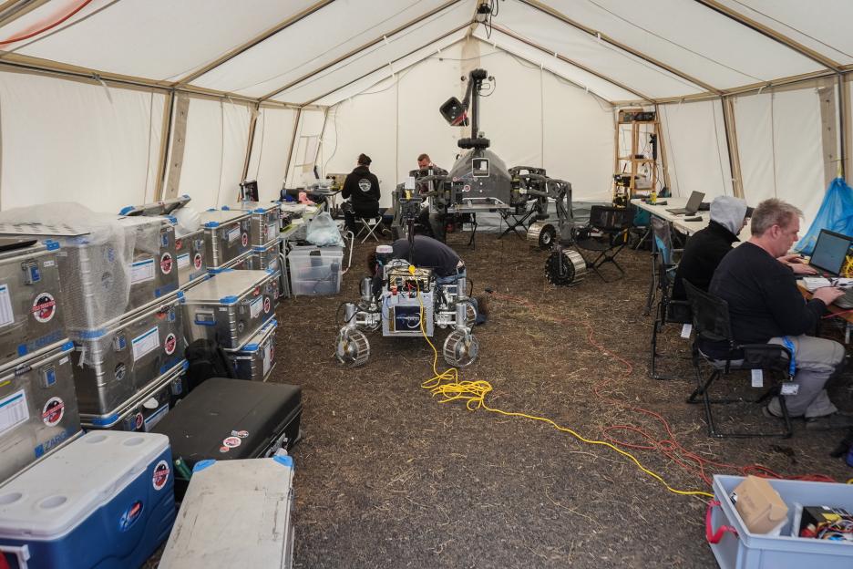 Researchers testing robots in a tent for a Mars mission.