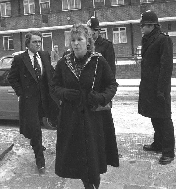 Linda Calvey and her brother-in-law Terence Calvey walking with police officers.