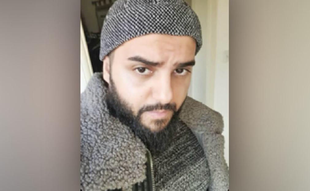 Jihad Al-Shamie wearing a patterned beanie, a grey zip-up sweater, and a jacket.