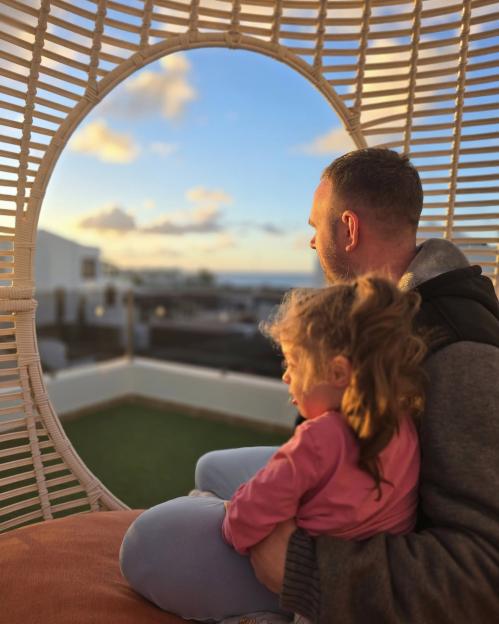Father and daughter watching sunset.