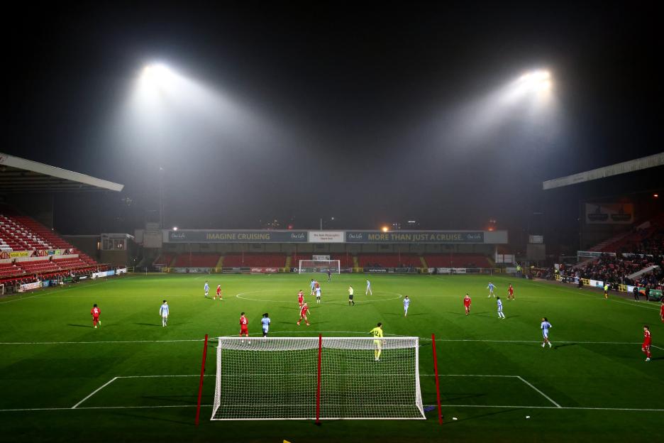 Soccer game at night under stadium lights.