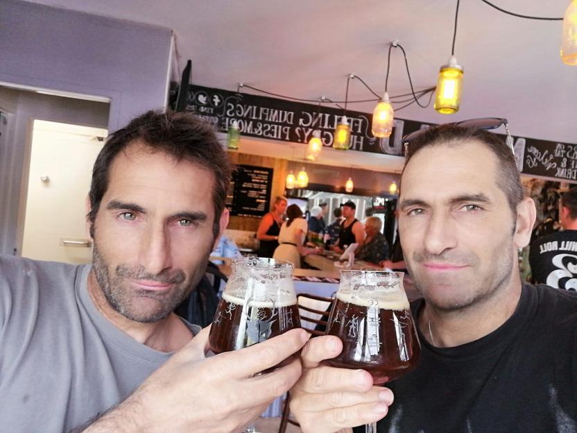 Two men toasting with glasses of beer.