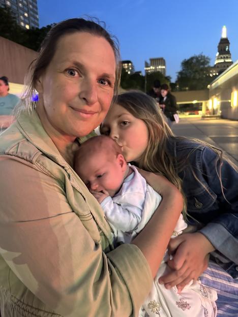 Woman holding newborn baby and daughter.