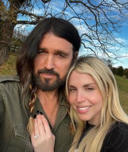 Billy Ray Cyrus and Firerose embrace outdoors, she shows off an engagement ring.