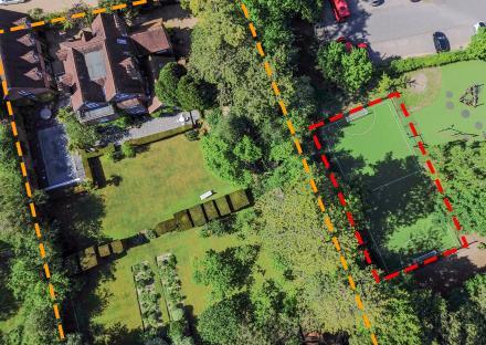 Aerial view of a house and garden next to a playing field.
