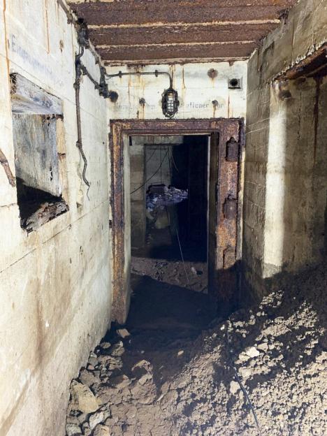 Interior of a World War II Nazi bunker with rusty metal door.