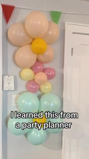 Pastel balloon flower arrangements on a wall.