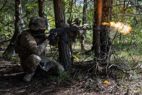 Ukrainian soldier firing a rifle during military training.