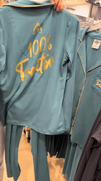Teal pajama set with "100% Traitor" in gold text.