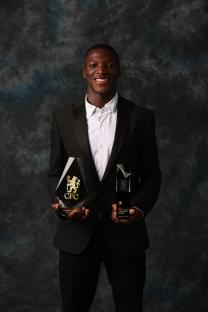 Moisés Caicedo holding two Chelsea FC awards.