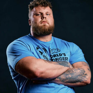 Portrait of a strongman with arms crossed, wearing a blue shirt that says