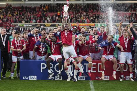 Wrexham soccer team celebrating a victory, raising a trophy.
