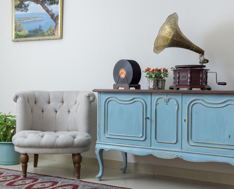 Retro living room with armchair, sideboard, and gramophone.