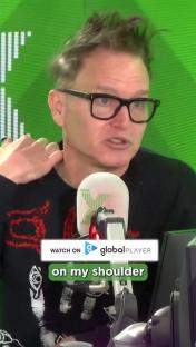 Mark Hoppus speaking into a microphone.