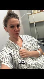 Woman in hospital gown sharing health update.