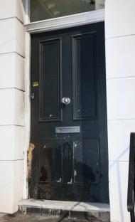 Damaged dark-colored front door.