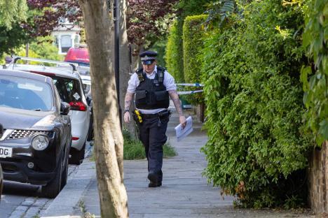 Police officer walking down a residential street.