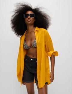 Woman wearing a yellow shirt and black shorts.