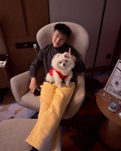 Zhao Xintong holding a Pomeranian.