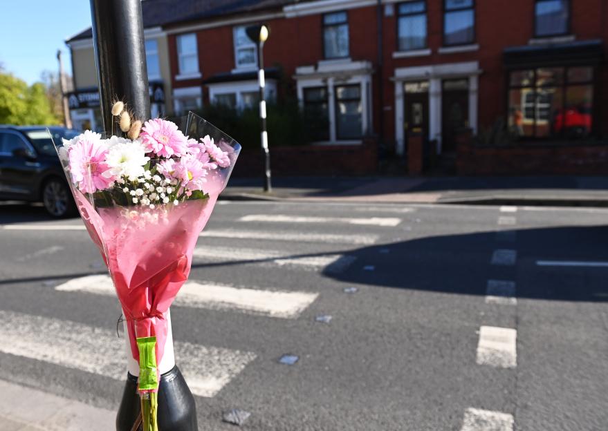 Flowers at a pedestrian crossing following a fatal hit-and-run.