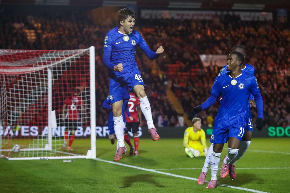 Facundo Buonanotte of Chelsea celebrates scoring a goal and jumping in the air.