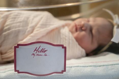 Blank name tag in front of sleeping newborn.