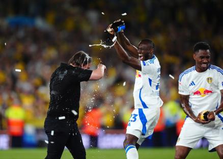 Leeds United manager Daniel Farke being sprayed with champagne by celebrating players.