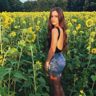 Woman standing in a field of sunflowers.