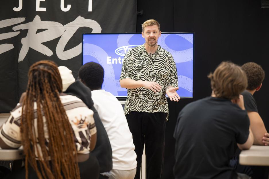 A man giving a presentation to a group of young people.