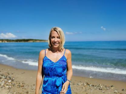 Woman in blue dress on beach.