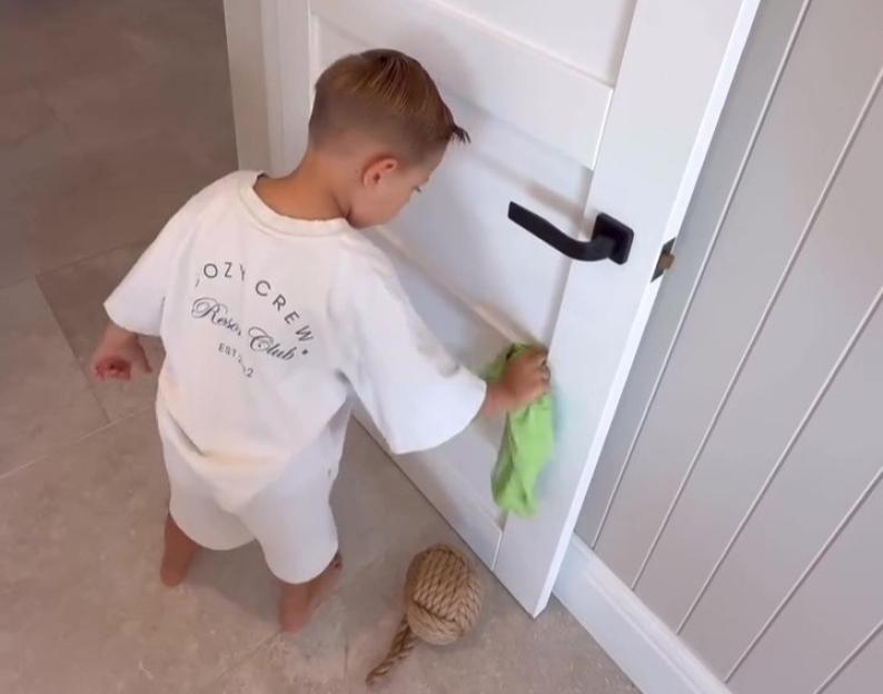 Young boy cleaning a door.