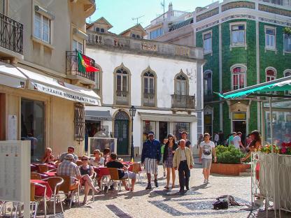 Lagos town square with people at cafes and shops.