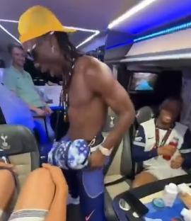 A shirtless man dances in a crowded Tottenham Hotspur team bus.