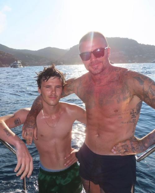 David and Romeo Beckham on a boat.