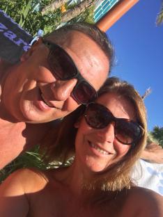 Selfie of a couple wearing sunglasses outdoors.