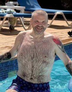 A man in swimming trunks in a pool.